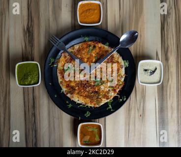 Une vue de dessus de pain plat avec viande sur une assiette ronde décorée de sauces sur une table en bois Banque D'Images