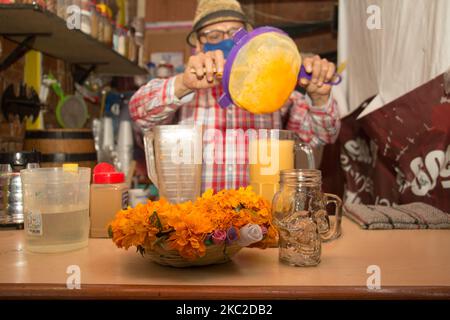 La pulque est une boisson alcoolisée fermentée par excellence du Mexique, dont l'origine est pré-hispanique et est faite à partir de la fermentation du mucilage et de la tige de maguey. Chaque année et à la veille du jour des morts, Agave 69, un petit endroit au sud de Mexico qui offre cette boisson, rend la fleur marigold typique guérie, connue pour être « la fleur des morts » et être un symbole de l'offrande dans la culture mexicaine. Cette année, en raison de la pandémie de Covid-19, ils ont mis en œuvre les mesures d'hygiène nécessaires pour que les amateurs de pulques puissent la déguster. Sur 21 octobre 2020 à Mexico, Mexique. (Photo de Ma Banque D'Images