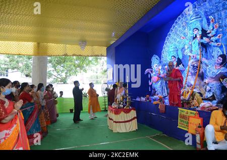 Les dévotés hindous indiens exécutent le rituel «Anjali» à l'occasion du festival «Mahashtami» de Durga Puja à Puja Pandal ou sur des plates-formes temporaires à Kolkata, en Inde, le samedi 24th octobre 2020. Les dévotés portant un masque de protection et maintiennent la distance sociale pendant le rituel d'exécution «Anjali» . Le festival Durga Puja marque la victoire de la déesse Durga sur le démon maléfique de buffle Mahishasura . Ainsi, le festival Durga Puja incarne la victoire du bien sur le mal. (Photo de Sonali Pal Chaudhury/NurPhoto) Banque D'Images