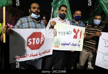 Des manifestants palestiniens lèvent des pancartes lors d'une manifestation pour protester contre la publication de dessins animés par le journal satirique français Charlie Hebdo, sont projetés comme offensant pour le prophète Mahomet, dans la ville de Rafah, dans le sud de la bande de Gaza, sur 24 octobre 2020. (Photo de Majdi Fathi/NurPhoto) Banque D'Images