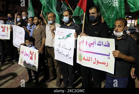 Des manifestants palestiniens lèvent des pancartes lors d'une manifestation pour protester contre la publication de dessins animés par le journal satirique français Charlie Hebdo, sont projetés comme offensant pour le prophète Mahomet, dans la ville de Rafah, dans le sud de la bande de Gaza, sur 24 octobre 2020. (Photo de Majdi Fathi/NurPhoto) Banque D'Images