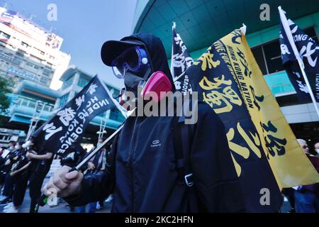 Environ 3000 personnes portant un bloc noir, portant des panneaux, des drapeaux sur l'indépendance de Hong Kong et des slogans exigent la libération des 12 personnes de Hong Kong qui ont été appréhendées par les autorités chinoises lors de leur voyage en bateau à Taïwan, à Taipei City, Taiwan, le 25 octobre 2020. Le groupe qui se jette sur les drapeaux nationaux de la Chine et qui agite les drapeaux de l'ancien Hong Kong britannique se réunit également à l'extérieur de la branche chinoise de Taipei de ''Bank of China''' avant de terminer la marche au Bureau économique, commercial et culturel de Hong Kong à Taipei. (Photo de CEng Shou Yi/NurPhoto) Banque D'Images