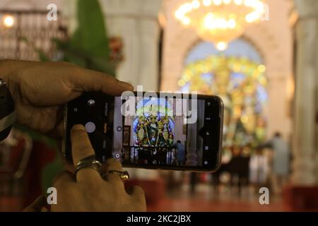 Un dévot capture des photos mobiles Sovabazar Boro Rajbari dura idol (palais royal de Shobhabazar) pendant le festival de Durga Puja au milieu de la pandémie de COVID-19 dans la ville de Kolkata, en Inde, sur 25 octobre 2020. (Photo de Debajyoti Chakraborty/NurPhoto) Banque D'Images