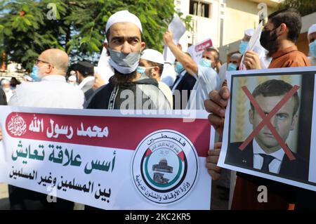 Les manifestants palestiniens lèvent des pancartes montrant une image barrée du président français Emmanuel Macron lors d'une protestation contre les publications d'une caricature du prophète Mahomet en France et les commentaires de Macron, à l'extérieur du Centre culturel français de la ville de Gaza, à 26 octobre 2020. (Photo de Majdi Fathi/NurPhoto) Banque D'Images