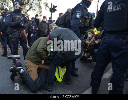 Des membres de la police ont arrêté l'un des nombreux manifestants Pro-Choice qui bloquent la circulation sur l'avenue Krasinskiego, dans le centre de Cracovie. Les activistes des droits des femmes, leurs partisans, ont organisé leur cinquième journée de manifestations à Cracovie et en Pologne, s'opposant à la restriction en cas de pandémie, pour exprimer leur colère face à la décision d'une cour suprême qui resserre les lois déjà strictes sur l'avortement. Lundi, 26 octobre 2020, à Cracovie, en Pologne. (Photo par Artur Widak/NurPhoto) Banque D'Images