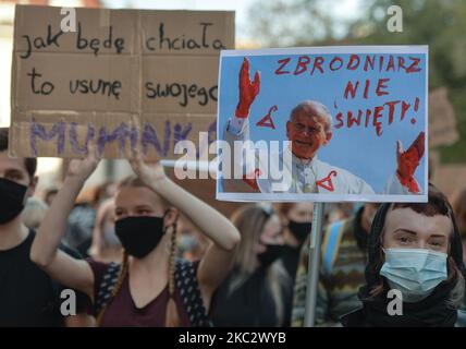 Un activiste pro-choix tient un écriteau avec une image du pape Jean-Paul II lors d'une manifestation dans la vieille ville de Cracovie. Les activistes des droits des femmes et leurs partisans ont organisé leur septième jour de manifestations à Cracovie et dans toute la Pologne, s'opposant à la restriction en cas de pandémie, pour exprimer leur colère contre la décision de la Cour suprême polonaise, qui a resserré les lois déjà strictes sur l'avortement. Sur 28 octobre 2020, à Cracovie, en Pologne. (Photo par Artur Widak/NurPhoto) Banque D'Images