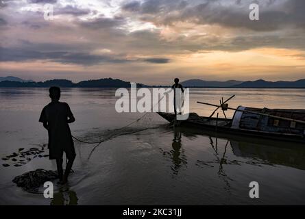 Les pêcheurs préparent et nettoient leurs filets de pêche sur la rivière Brahmaputra, au coucher du soleil, à Guwahati, le 31 octobre 2020. (Photo de David Talukdar/NurPhoto) Banque D'Images