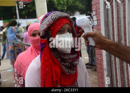 Un responsable de la sécurité vérifie la température corporelle des visiteurs à l'entrée du Musée national du Bangladesh après la réouverture à la suite de la pandémie Covid-19 à Dhaka, au Bangladesh, sur 1 novembre 2020. (Photo par Mamunur Rashid/NurPhoto) Banque D'Images