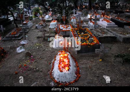 Tombes décorées de vos proches avec des bougies et des fleurs à l'occasion de la Journée de tous les âmes au cimetière chrétien indien, à 2 novembre 2020, à New Delhi, Inde. Le jour de l'âme, également appelé « le jour des morts », est une journée catholique romaine de commémoration pour les amis et les proches qui sont morts. (Photo de Mayank Makhija/NurPhoto) Banque D'Images