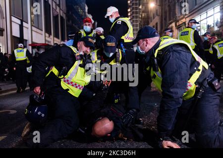 Un homme est détenu par des policiers en tant que manifestants de la million Mask March et des manifestants anti-verrouillage manifestent, dans le cadre de l'épidémie du coronavirus (COVID-19) à Londres, en Grande-Bretagne 5 novembre 2020. (Photo de Maciek Musialek/NurPhoto) Banque D'Images