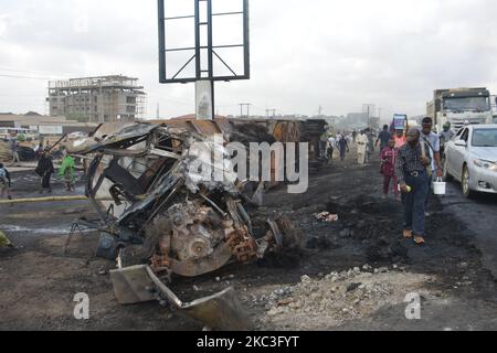 Des passants marchent au milieu de voitures brûlées après qu'un pétrolier a explosé sur l'autoroute Lagos-Ibadan sur 7 novembre 2020, dans l'État d'Ogun, tuant deux personnes dans un immense feu. Plusieurs véhicules ont été engloutis dans un incendie qui a commencé samedi matin le long de la section du pont Kara de l'autoroute Lagos-Ibadan, l'incident a entraîné une circulation intense sur cette section de l'autoroute samedi matin. (Photo par Olukayode Jaiyeola/NurPhoto) Banque D'Images