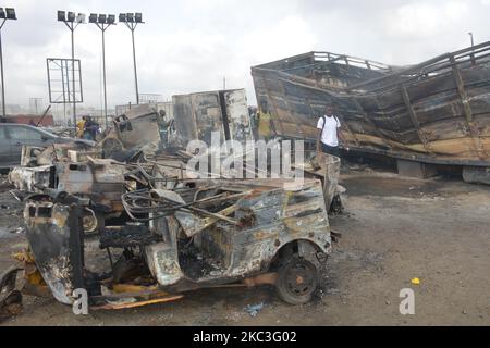 Des passants marchent au milieu de voitures brûlées après qu'un pétrolier a explosé sur l'autoroute Lagos-Ibadan sur 7 novembre 2020, dans l'État d'Ogun, tuant deux personnes dans un immense feu. Plusieurs véhicules ont été engloutis dans un incendie qui a commencé samedi matin le long de la section du pont Kara de l'autoroute Lagos-Ibadan, l'incident a entraîné une circulation intense sur cette section de l'autoroute samedi matin. (Photo par Olukayode Jaiyeola/NurPhoto) Banque D'Images