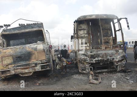 Des passants marchent au milieu de voitures brûlées après qu'un pétrolier a explosé sur l'autoroute Lagos-Ibadan sur 7 novembre 2020, dans l'État d'Ogun, tuant deux personnes dans un immense feu. Plusieurs véhicules ont été engloutis dans un incendie qui a commencé samedi matin le long de la section du pont Kara de l'autoroute Lagos-Ibadan, l'incident a entraîné une circulation intense sur cette section de l'autoroute samedi matin. (Photo par Olukayode Jaiyeola/NurPhoto) Banque D'Images