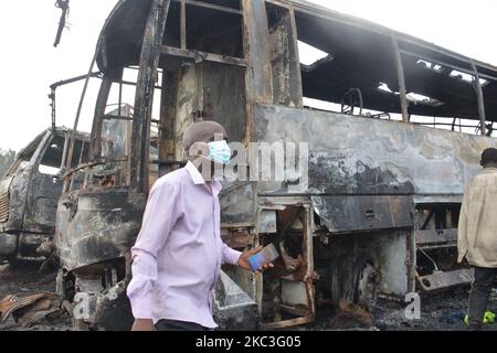 Une promenade de passage au milieu de voitures brûlées après qu'un pétrolier a explosé sur l'autoroute Lagos-Ibadan sur 7 novembre 2020, dans l'État d'Ogun, tuant deux personnes dans un immense feu. Plusieurs véhicules ont été engloutis dans un incendie qui a commencé samedi matin le long de la section du pont Kara de l'autoroute Lagos-Ibadan, l'incident a entraîné une circulation intense sur cette section de l'autoroute samedi matin. (Photo par Olukayode Jaiyeola/NurPhoto) Banque D'Images