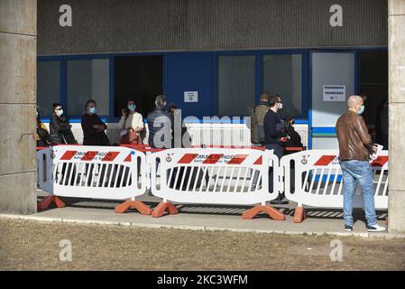 Les personnes en file d'attente pour écouvillonner au point d'écouvillonnage situé sous le stade Euganeo. Ils portent tous des masques protecteurs, sont espacés d'un mètre et sont contrôlés et assistés par le personnel médical et non par l'armée italienne. Le 11 novembre 2020, à Padoue, en Italie. Avec l'augmentation de la courbe des infections et par conséquent des infectés, les hôpitaux de la Vénétie et plus particulièrement de Padoue et Schiavonia sont proches de s'effondrer. Pour alléger la charge de travail éprouvante des médecins et des infirmières, l'armée a pris sur le terrain avec son personnel qualifié. Les médecins et infirmières de l'armée d'aujourd'hui preux Banque D'Images