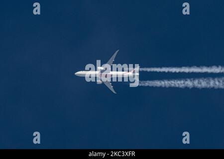 Un Boeing 777 Emirates vol dans le ciel bleu à 39,000 pieds de l'aéroport international DXB de Dubaï aux Émirats Arabes Unis à MANCHESTER MAN sur le vol britannique n° EK17. Le Boeing B777-300 777-31H(ER), un avion à large corps survolant, est immatriculé A6-EGV et est alimenté par 2x moteurs à réaction GE. Emirates vole pendant la pandémie du coronavirus Covid-19 avec de gros avions à corps large. La ligne aérienne survolée crée contrail ou chemTrail pendant la croisière, formant une ligne blanche de sentier de condensation dans l'atmosphère derrière elle. Eindhoven, pays-Bas, le 11 novembre 2020 (photo de Nicolas Economou/NurPhoto) Banque D'Images