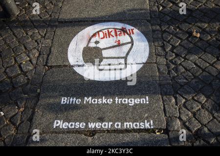 Un panneau indiquant l'obligation de porter un masque est peint avec le texte rouge 'Dictatutation' à Herrmannplatz à Berlin, Allemagne sur 12 novembre 2020. (Photo par Emmanuele Contini/NurPhoto) Banque D'Images