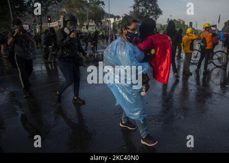 Une femme charge son jeune fils. Dans le cadre de la manifestation et de la protestation pour la liberté des prisonniers politiques mapuche, des prisonniers de la révolte sociale et des subverses. Sur 13 novembre 2020. À Santiago du Chili. (Photo de Claudio Abarca Sandoval/NurPhoto) Banque D'Images