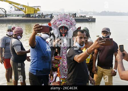 Les gens cliquent sur une image de selfie lors d'une immersion de la déesse Kali idol lors d'une immersion à Kolkata, Inde, 17 novembre, 2020. (Photo par Indranil Aditya/NurPhoto) Banque D'Images