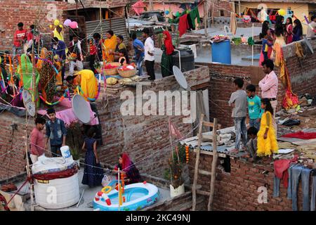 Des dévotés hindous exécutant des rituels et adorant le Dieu du Soleil dans des étangs artificiels créés sur les toits lors du festival Chhath Puja à New Delhi sur 20 novembre 2020. Le gouvernement de Delhi a interdit les célébrations communautaires de Chhath Puja sur les rives, les ghats et les temples, en raison d'un nombre croissant de cas de COVID-19. (Photo de Mayank Makhija/NurPhoto) Banque D'Images