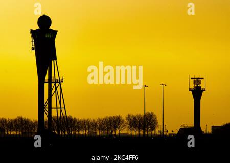 Heure d'or de l'aube et du lever du soleil avec couleurs chaudes du ciel de l'heure magique à l'aéroport international ECAM d'Amsterdam Schiphol AMS aux pays-Bas. Images tôt le matin de l'industrie de l'aviation avec la silhouette de la tour de contrôle et de l'avion d'atterrissage dans le paysage de SkyScape européen coloré. 22 novembre 2020 (photo de Nicolas Economou/NurPhoto) Banque D'Images