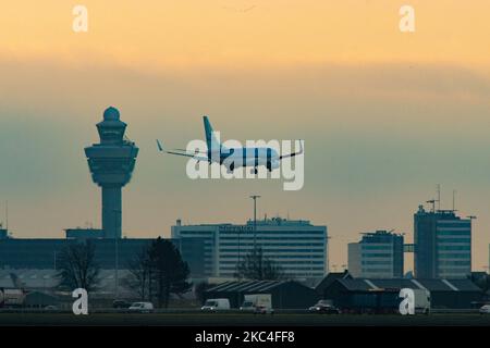 Un Boeing 737 de KLM débarquant avant le lever du soleil. Heure d'or de l'aube et du lever du soleil avec couleurs chaudes du ciel de l'heure magique à l'aéroport international ECAM d'Amsterdam Schiphol AMS aux pays-Bas. Images tôt le matin de l'industrie de l'aviation avec la silhouette de la tour de contrôle et de l'avion d'atterrissage dans le paysage de SkyScape européen coloré. 22 novembre 2020 (photo de Nicolas Economou/NurPhoto) Banque D'Images