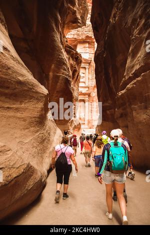 Les touristes marchent vers le site du trésor à Petra à travers le Siq, l'étroite fente-canyon qui sert de passage à l'entrée de la ville cachée de PET Banque D'Images