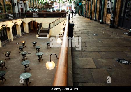 Les tables vides d'un restaurant temporairement fermé se trouvent dans la cour inférieure d'un marché couvert de Covent Garden à Londres, en Angleterre, sur 23 novembre 2020. Dans toute l'Angleterre, les magasins non essentiels, ainsi que les bars, restaurants et autres commerces d'accueil restent fermés dans le cadre du deuxième confinement national du coronavirus, commencé à 5 novembre et qui doit expirer à 2 décembre. (Photo de David Cliff/NurPhoto) Banque D'Images