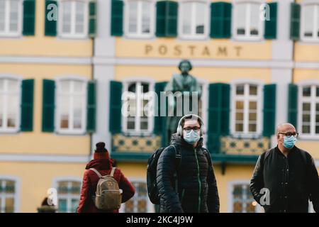 Des personnes avec des masques de visage marchent devant un monument de Ludwig van Beethoven à Bonn, en Allemagne, sur 24 novembre 2020. (Photo de Ying Tang/NurPhoto) Banque D'Images