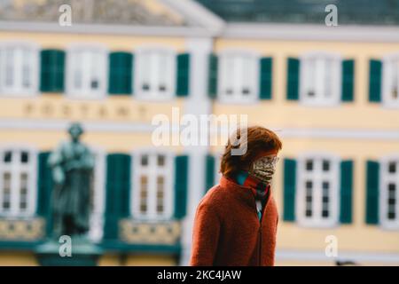 Des personnes avec des masques de visage marchent devant un monument de Ludwig van Beethoven à Bonn, en Allemagne, sur 24 novembre 2020. (Photo de Ying Tang/NurPhoto) Banque D'Images