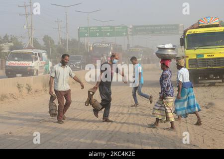 Les gens marchent sur une route poussiéreuse et animée à Dhaka, au Bangladesh, sur 25 novembre 2020. L'état de l'air de la ville de Dhaka s'aggrave jour après jour à un rythme alarmant au cours des 2 dernières années en raison de nouvelles constructions de routes dans la plupart des parties de la ville. (Photo par Mamunur Rashid/NurPhoto) Banque D'Images