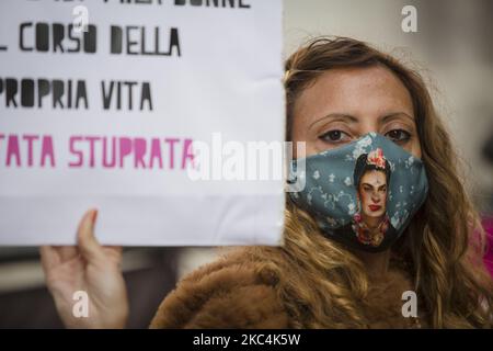 Italie, Rome: Une femme portant un masque facial de protection représentant la peintre mexicaine Frida Kahlo tient une bannière lors d'une manifestation à l'occasion de la Journée internationale pour l'élimination de la violence contre les femmes sur la place Montecitorio à Rome, 25 novembre 2020. (Photo de Christian Minelli/NurPhoto) Banque D'Images