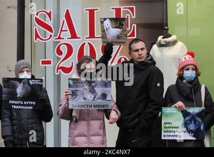 Les militants des droits des animaux tiennent des pancartes lors d'une manifestation intitulée « Bloody sale » contre le commerce des fourrures le vendredi noir à Kiev, en Ukraine, le 27 novembre 2020. Les militants ukrainiens des droits des animaux ont manifesté devant les boutiques de fourrures de la capitale ukrainienne pour marquer la Journée mondiale sans fourrure. Les manifestants exhortant les consommateurs à ne pas acheter de produits à fourrure pendant les ventes du Vendredi fou. World fur Free Friday (WFFF) est une manifestation contre les entreprises et les magasins qui vendent de la fourrure tenue dans le monde entier pour sauver les animaux et contre le commerce de la fourrure. (Photo par STR/NurPhoto) Banque D'Images