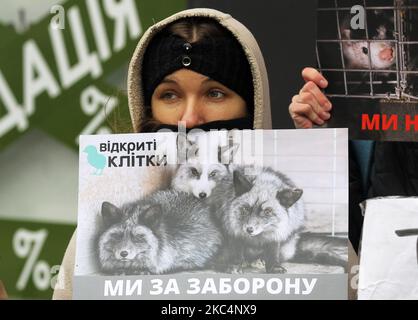 Un militant des droits des animaux tient un écriteau lors d'une manifestation intitulée « Bloody sale » contre le commerce des fourrures le vendredi noir à Kiev, en Ukraine, le 27 novembre 2020. Les militants ukrainiens des droits des animaux ont manifesté devant les boutiques de fourrures de la capitale ukrainienne pour marquer la Journée mondiale sans fourrure. Les manifestants exhortant les consommateurs à ne pas acheter de produits à fourrure pendant les ventes du Vendredi fou. World fur Free Friday (WFFF) est une manifestation contre les entreprises et les magasins qui vendent de la fourrure tenue dans le monde entier pour sauver les animaux et contre le commerce de la fourrure. (Photo par STR/NurPhoto) Banque D'Images