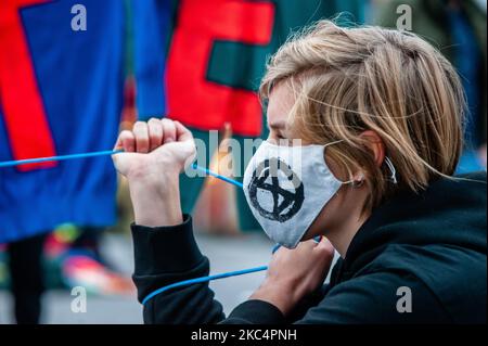 Un activiste du climat tient une bannière tout en portant un masque avec le logo de la rébellion d'extinction, lors de la manifestation de cirque contre le Vendredi noir, à Utrecht, sur 27 novembre 2020. (Photo par Romy Arroyo Fernandez/NurPhoto) Banque D'Images