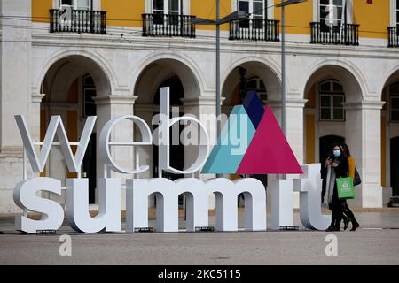 Les personnes portant des masques de visage marchent au-delà d'un logo 3D de Sommet de Web dans le centre de Lisbonne, Portugal sur 30 novembre 2020. Le Sommet du Web, la plus grande conférence technologique d'Europes, devait se tenir à nouveau à Lisbonne cette année, mais sera au contraire entièrement en ligne de 2 décembre à 4 décembre en raison de la pandémie du coronavirus COVID-19. (Photo par Pedro Fiúza/NurPhoto) Banque D'Images