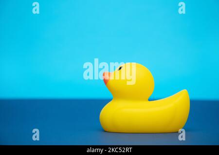 Illustration 3D d'un canard en caoutchouc jaune sur une surface bleu foncé sur fond cyan Banque D'Images