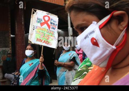 Des activistes indiens qui combattrait le masque protecteur tiennent un écriteau - marchez dans un rassemblement pour marquer la Journée mondiale du sida à Kolkata, Inde, le mardi 1 décembre 2020. Les écriteaux « ne pas s'en tenir au sida, pas aux patients », à gauche, « cochez un seul partenaire. Utilisez des préservatifs," centre, "ne pas réutiliser les seringues, les aiguilles, les lames ou les rasoirs utilisés par d'autres," droit. (Photo de Debajyoti Chakraborty/NurPhoto) Banque D'Images