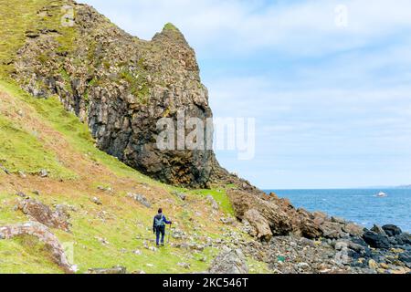 Un marcheur sur la piste côtière au-dessous de Ben Tianavaig, près de Portree, île de Skye, Écosse, Royaume-Uni Banque D'Images