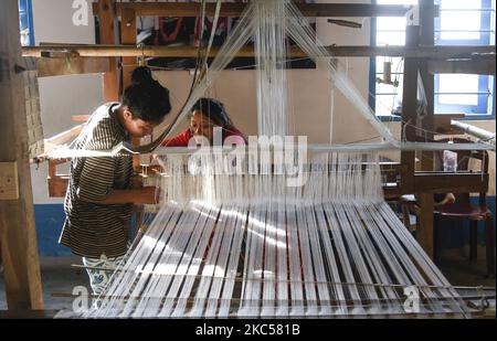 Étudiant à tisser des costumes de soie et de coton dans un métier à main traditionnel à une unité de fabrication de l'Académie Parijat à Guwahati, Assam, Inde, le 25 novembre 2020. L'Académie Parijat est une école à but non lucratif pour les enfants défavorisés, pour développer et explorer le talent et les potentialités des enfants par l'éducation. (Photo de David Talukdar/NurPhoto) Banque D'Images