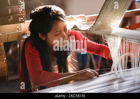 Étudiant à tisser des costumes de soie et de coton dans un métier à main traditionnel à une unité de fabrication de l'Académie Parijat à Guwahati, Assam, Inde, le 25 novembre 2020. L'Académie Parijat est une école à but non lucratif pour les enfants défavorisés, pour développer et explorer le talent et les potentialités des enfants par l'éducation. (Photo de David Talukdar/NurPhoto) Banque D'Images