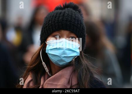 Une femme portant un masque de visage traverse Oxford Circus à Londres, en Angleterre, sur 5 décembre 2020. Londres est revenue aux restrictions de niveau 2 ou de « haute alerte » sur le coronavirus depuis la fin de la période de quatre semaines de confinement à l'échelle de l'Angleterre mercredi dernier, ce qui signifie la réouverture de magasins et d'entreprises d'accueil non essentiels au cours de la période des fêtes. Les règles des trois niveaux d'Angleterre ont été renforcées d'avant le verrouillage de novembre, mais les pubs et les restaurants ont été les plus durement touchés. Dans le West End de Londres, pendant ce temps, Oxford Street et Regent Street étaient tous deux remplis de Christ Banque D'Images