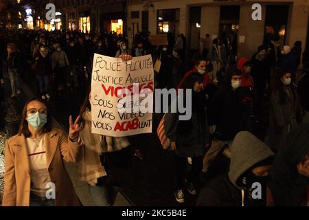 Une jeune femme gesturées comme une autre tient un écriteau lisant "police floue, justice aveugle". Plus de 5000 000 manifestants ont une fois de plus protesté contre le projet de loi appelé « Loi sur la sécurité mondiale » promu par le président français Macron et sa majorité. Le projet de loi sur la "loi mondiale sur la sécurité" interdonnera également à quiconque de photographier ou de filmer des membres de la police s'il n'est pas bafoué : les transgresseurs pourraient être condamnés jusqu'à un an de prison et une amende de €45,000 ans. Le projet de loi prévoit également de généraliser la reconnaissance faciale dans les espaces publics comme en Chine.le défenseur français des droits, la Commission nationale française des droits de l'homme (administrative Banque D'Images