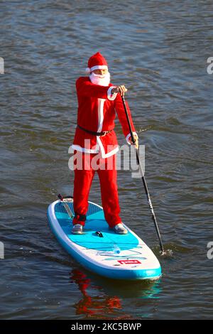 Les surfeurs en paddleboard vêtus des costumes du Père Noël flottent sur la Vistule lors d'un événement caritatif le jour de Saint Nicolas à Cracovie, en Pologne. 6 décembre 2020. (Photo de Beata Zawrzel/NurPhoto) Banque D'Images