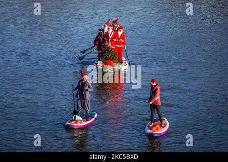 Les surfeurs en paddleboard vêtus des costumes du Père Noël flottent sur la Vistule lors d'un événement caritatif le jour de Saint Nicolas à Cracovie, en Pologne. 6 décembre 2020. (Photo de Beata Zawrzel/NurPhoto) Banque D'Images