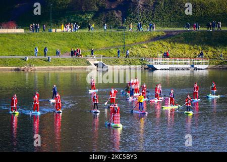 Les surfeurs en paddleboard vêtus des costumes du Père Noël flottent sur la Vistule lors d'un événement caritatif le jour de Saint Nicolas à Cracovie, en Pologne. 6 décembre 2020. (Photo de Beata Zawrzel/NurPhoto) Banque D'Images