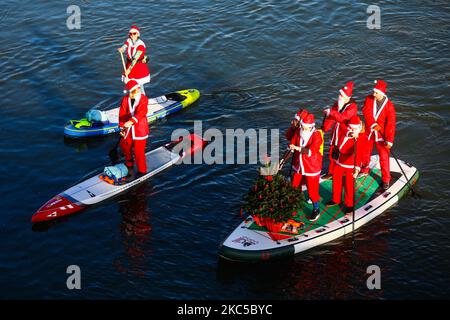 Les surfeurs en paddleboard vêtus des costumes du Père Noël flottent sur la Vistule lors d'un événement caritatif le jour de Saint Nicolas à Cracovie, en Pologne. 6 décembre 2020. (Photo de Beata Zawrzel/NurPhoto) Banque D'Images