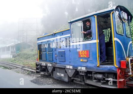 Le chauffeur de train salue avec une gestue à la main. Le Darjeeling Himalayan Railway ou DHR ou connu comme Toy train en raison de la voie étroite 2ft sur les pentes de l'Himalaya en Inde. Le train relie New Jalpaiguri et Darjeeling au Bengale-Occidental, construit en 1881 et atteint une altitude de 2200m. Au-dessus du niveau de la mer. La locomotive utilise du diesel, mais des locomotives à vapeur de classe B sont également utilisées et font le trajet entre les habitants et les touristes de Ghum et Darjeeling, avec une vue panoramique sur les montagnes, les pentes, la plantation de thé et passent des villes à côté des maisons et des marchés. Depuis 1999 UNESC Banque D'Images