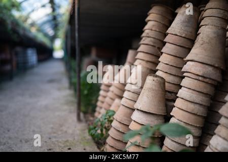 Gros plan des piles de pots de fleurs de terre cuite anciens et altérés dans le hangar de jardinage Banque D'Images