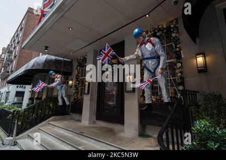 Effigies du Premier ministre britannique Boris Johnson dans un costume festif étincelant, les drapeaux britanniques sont exposés devant le 34 Restaurant de Mayfair, le 12 décembre 2020 à Londres, en Angleterre. Londres risque d'entrer dans les restrictions de niveau 3 du coronavirus avant Noël, car les taux d'infection dans la capitale sont maintenant au-dessus de la moyenne nationale et continuent d'augmenter, le gouvernement étant tenu de revoir les allocations pour toutes les régions d'Angleterre le 16 décembre. (Photo de Wiktor Szymanowicz/NurPhoto) Banque D'Images